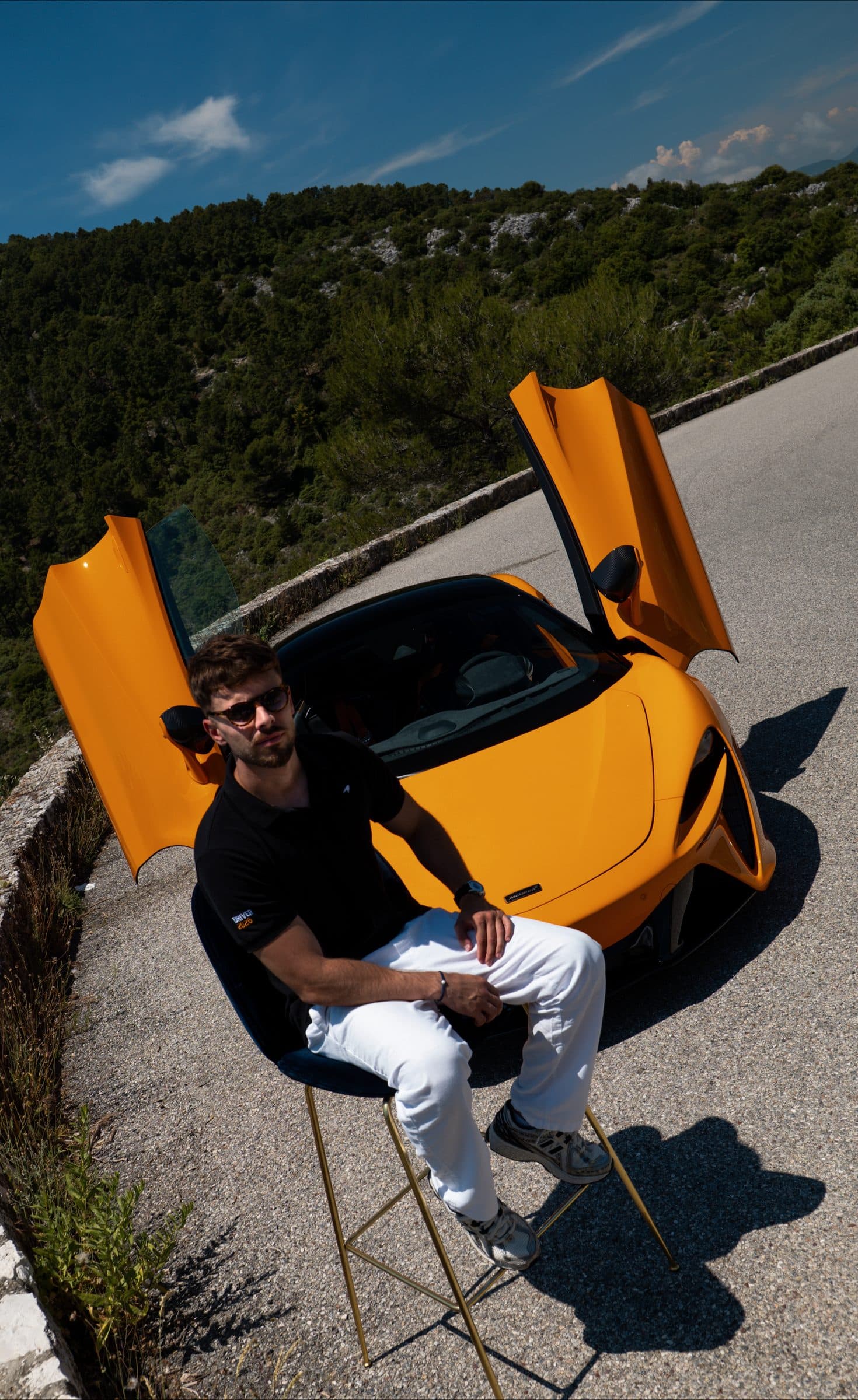 Lucas Valkre assis devant la McLaren, portes ouvertes