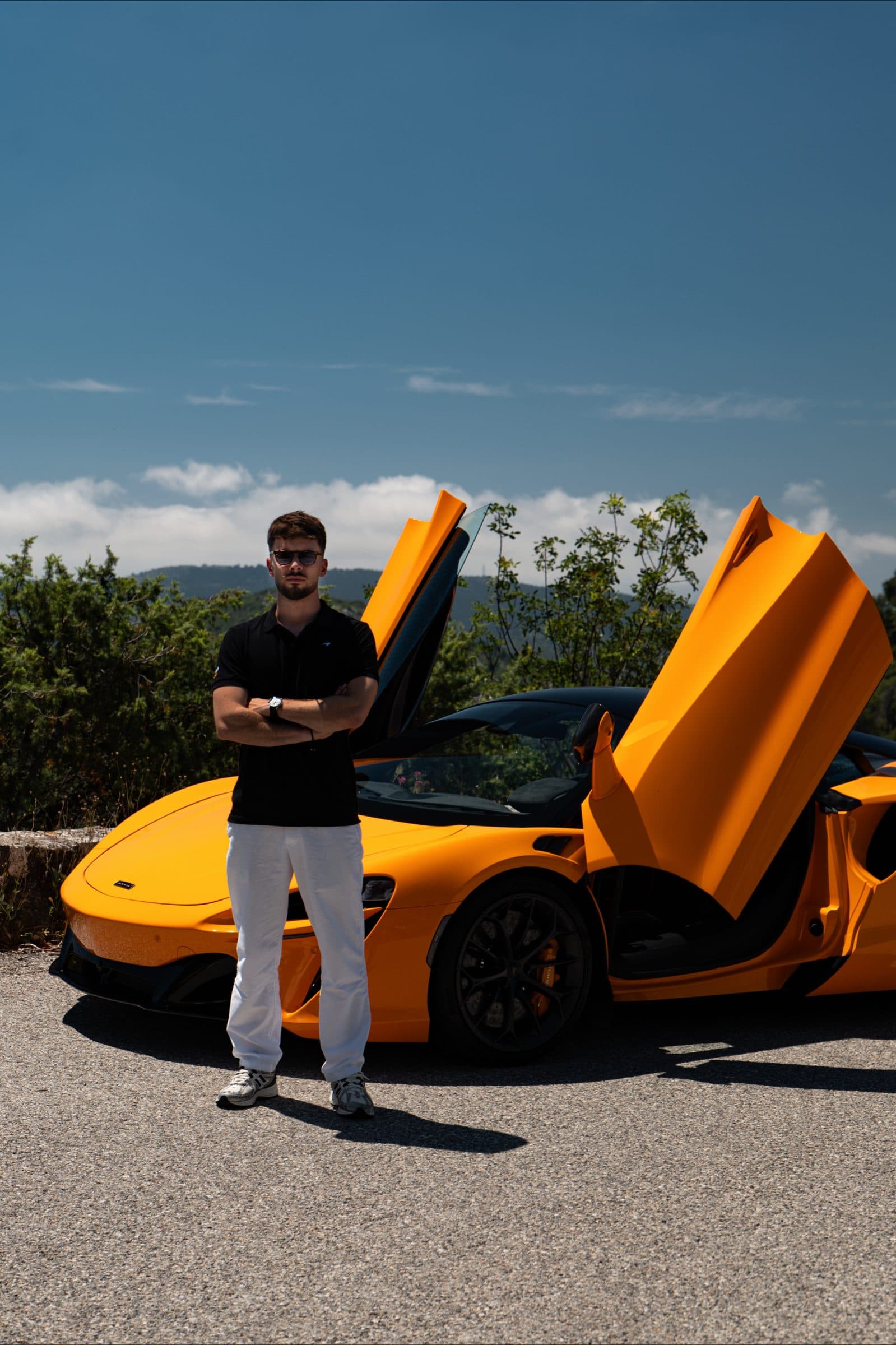 Portrait de Lucas Valkre, bras croisés, devant la McLaren